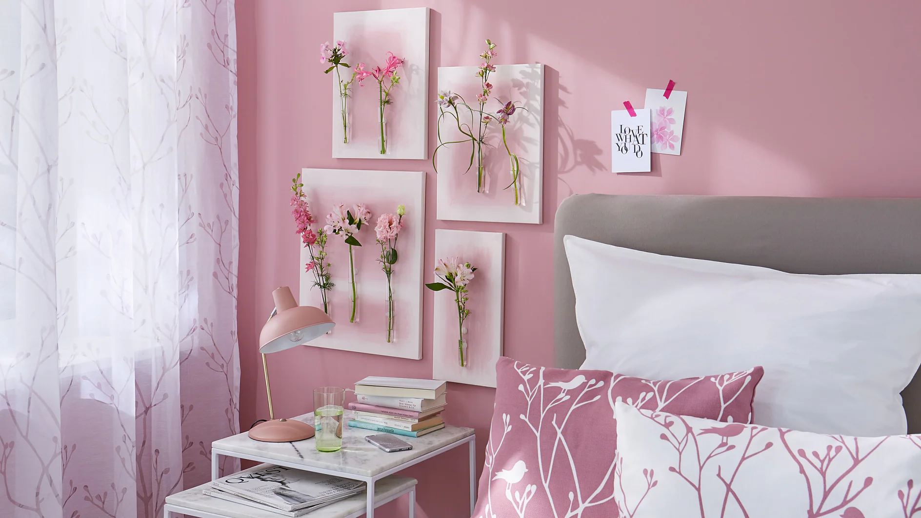 Gemalte Blumen hat jeder an der Wand hängen, aber echte? Dafür braucht man ein wenig Basteltalent, Leinwand, Reagenzgläser, das richtige Klebe-Know-how und natürlich die Hauptdarsteller: mehrere ungewöhnliche Einzelblüten! Hier in abgestuften Tönen von Weiß bis Magenta als schöne Ergänzung zu der rosaroten Umgebung.