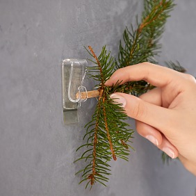 Holzstäbe mit den Enden in die Haken schieben.