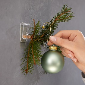 Mit Kugeln und Anhängern festlich dekorieren.