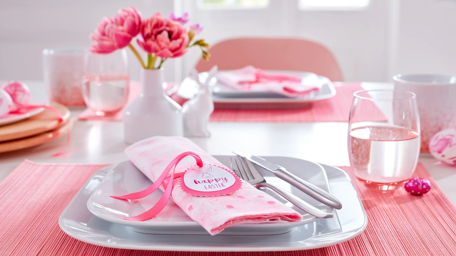Pink ist auf dieser Ostertafel Trumpf. Die Servietten auf jedem Platz tragen dazu passend einen selbst gemachten Serviettenring mit geradlinigem Mümmelmann-Porträt und guten Wünschen zum Frühlingsfest.