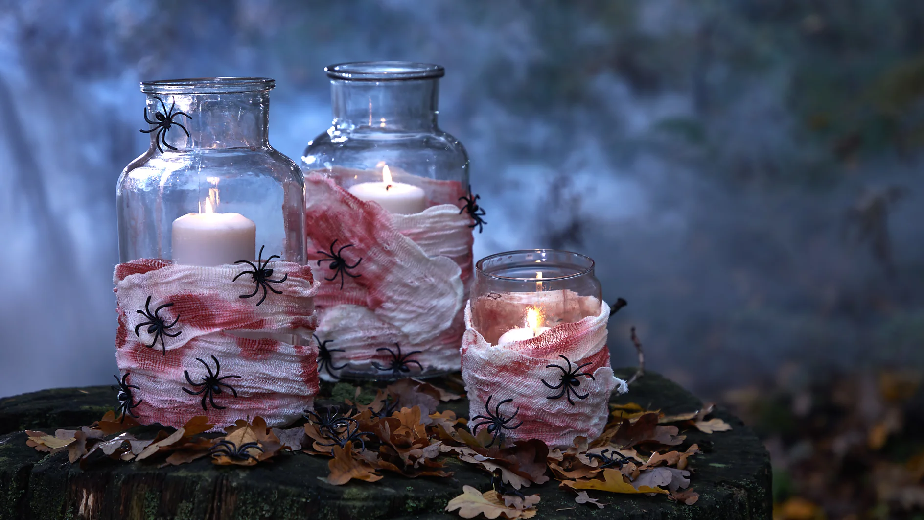 Achtung: Hier herrscht Ekelalarm! Aber genau darum geht es ja an Halloween. Deshalb verzieren wir die Glaswindlichter mit (kunst-)blutverschmierten Mullbinden und vielen ekligen Spinnen!