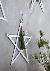 Wir haben es immer geahnt: Zollstöcke können mehr, als nur abmessen. Zum Stern gefaltet und festlich geschmückt, machen sie sich auch sehr gut als Weihnachtsdeko an der Wand!