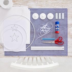 Das brauchen wir:
Weißer geprägter Karton, Vorlage Sterne, Schere, Bleistift, Lineal, Papierdraht,
weiße Metallringe in unterschiedlichen Größen, weißes Organzaband 7 mm breit, 
tesa® Powerstrips Deckenhaken
tesa® Easy Stick ecoLogo®

Zeitaufwand: ca. 20 Minuten pro Kranz
