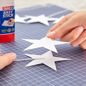 Ein ca. 23 cm langes Stück vom Papierdraht abschneiden, auf den Stern auflegen und zweiten Stern aufkleben. Gut andrücken. Je nach Größe des Kranzes 10 bis 16 Stück fertigen.