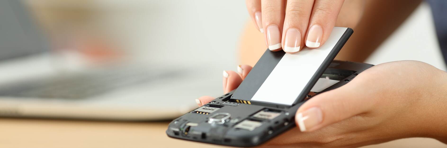 Weibliche Hand platziert Batterie in einem Smartphone