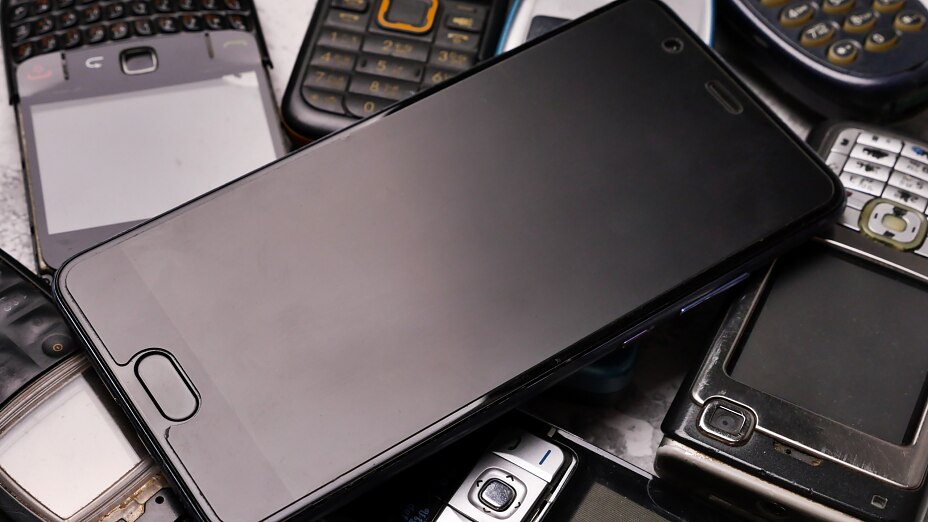 Ein Smartphone auf einem Haufen obsoleter Handys. Ein Smartphone auf einem Haufen obsoleter Handys.