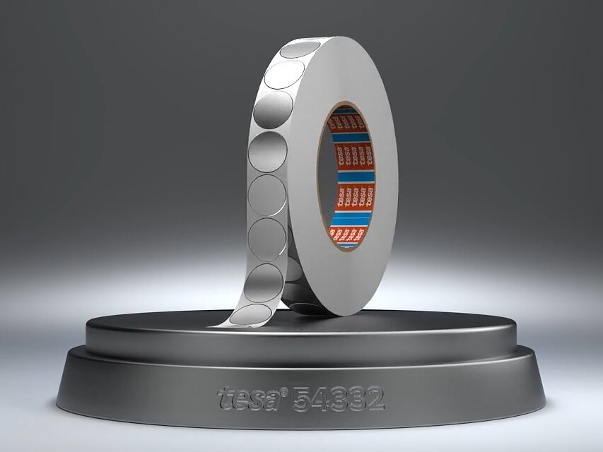 Ein Metallring mit gemusterter Oberfläche steht vertikal auf einem runden Sockel. Der innere Teil des Rings ist blau und orange gestaltet. In den Sockel ist der Text „itseez3 5892“ eingraviert. Der Hintergrund ist ein Farbverlauf aus Grautönen. (This text has been generated by AI)