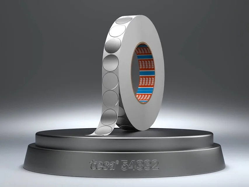 Ein Metallring mit gemusterter Oberfläche steht vertikal auf einem runden Sockel. Der innere Teil des Rings ist blau und orange gestaltet. In den Sockel ist der Text „itseez3 5892“ eingraviert. Der Hintergrund ist ein Farbverlauf aus Grautönen. (This text has been generated by AI)