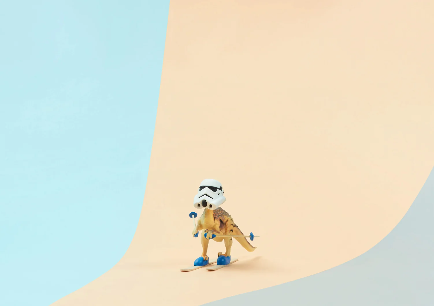 Ein kleiner Spielzeugdinosaurier mit weißem Helm und blauer Skiausrüstung steht auf einem Paar Ski, das mit Tesa-Klebeband befestigt ist. Der Hintergrund ist ein sanfter Farbverlauf aus Hellblau und Beige, der eine skurrile, minimalistische Atmosphäre schafft. (This text has been generated by AI)