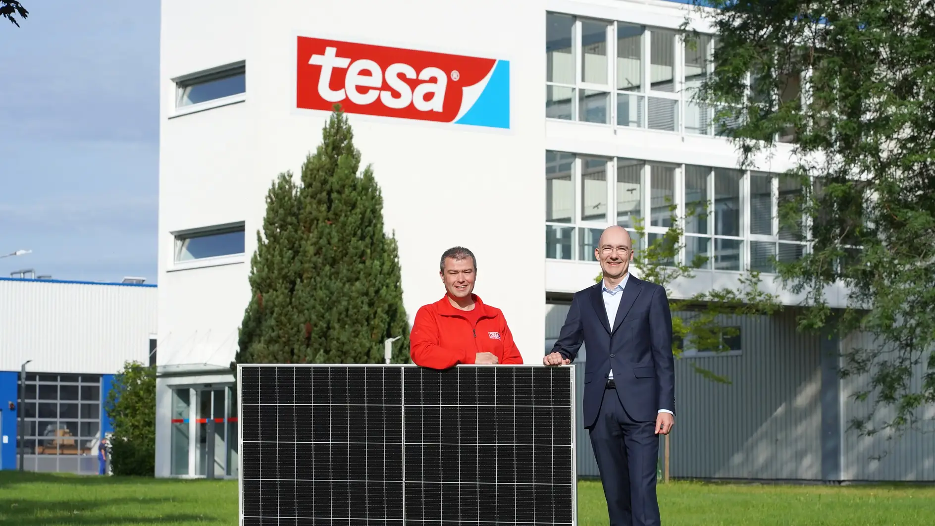 tesa setzt auf Nachhaltigkeit: Werksleiter Holger Rauth (rechts) und Tobias Wolter, Teamleiter Energie und Ausbildung (links), zeigen stolz eines der rund 13.000 Photovoltaikmodule, die das Werk zukünftig mit Solarenergie versorgen werden.
