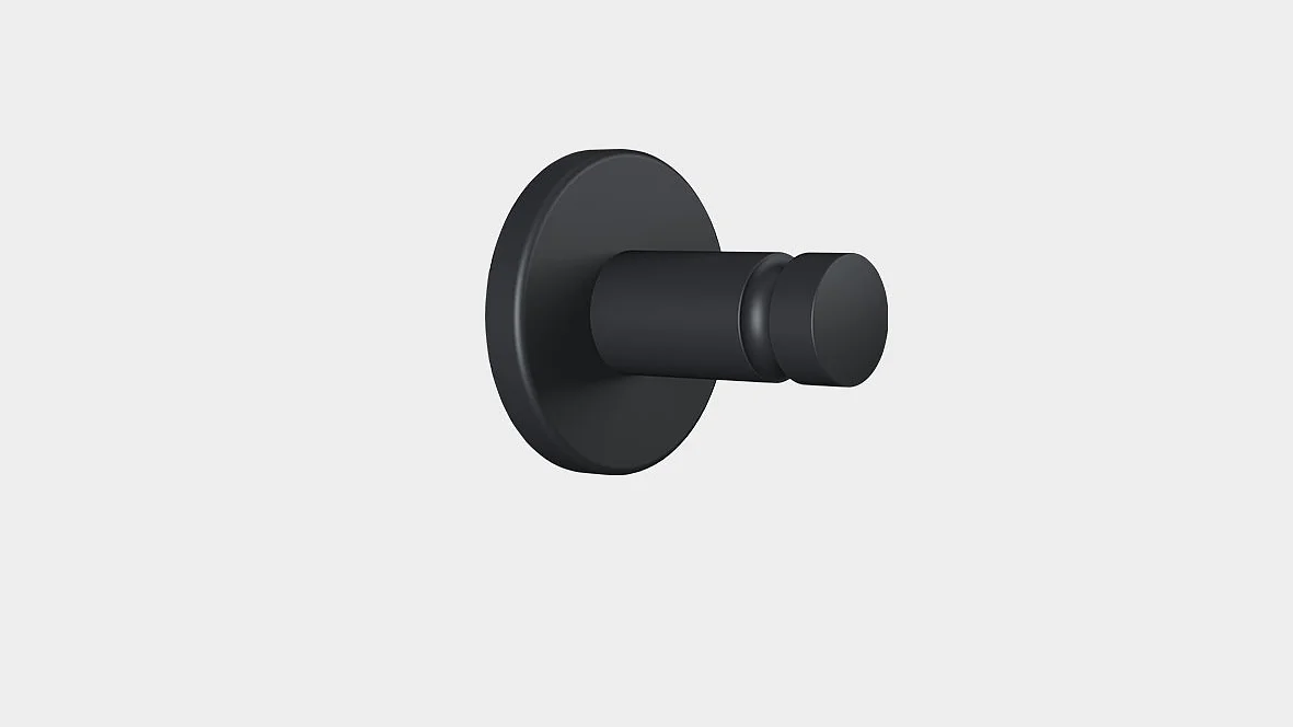 A black cylindrical wall hook mounted on a flat circular base against a plain light gray background secured with tesa tape.
