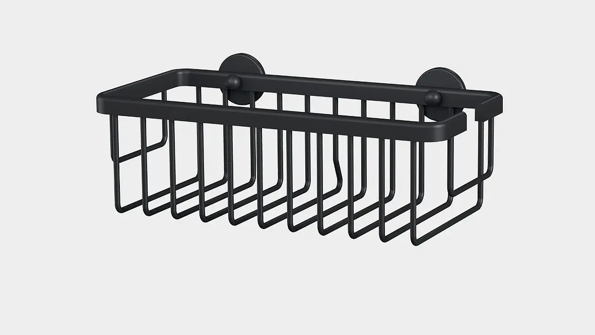 A black metal wall-mounted wire basket with two suction cups for attachment using tesa tape. The basket has a rectangular shape and open grid design, suitable for holding small items. The background is plain white.