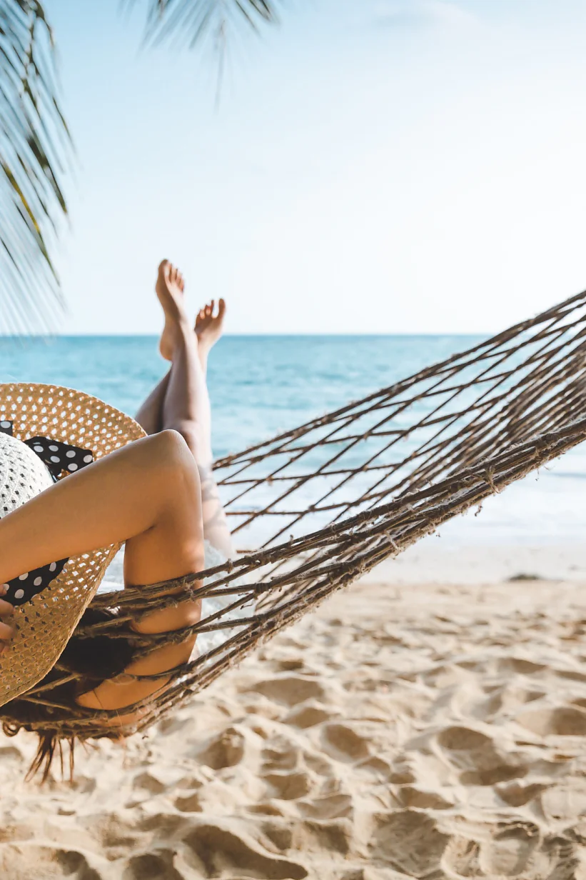 Summer travel vacation concept, Happy traveler asian woman with white bikini relax in hammock on beach in Koh mak, Thailand
