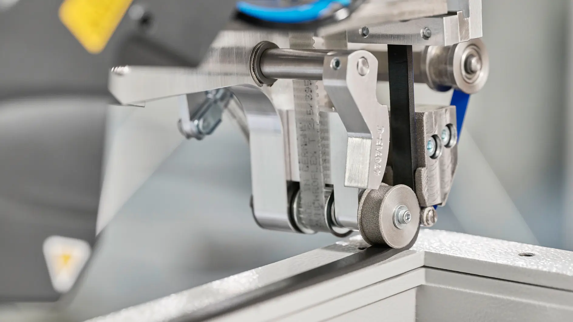 tesa-markierte Industriemaschine, die in einer Fertigungsumgebung Klebeband auf einen Metallrahmen aufbringt