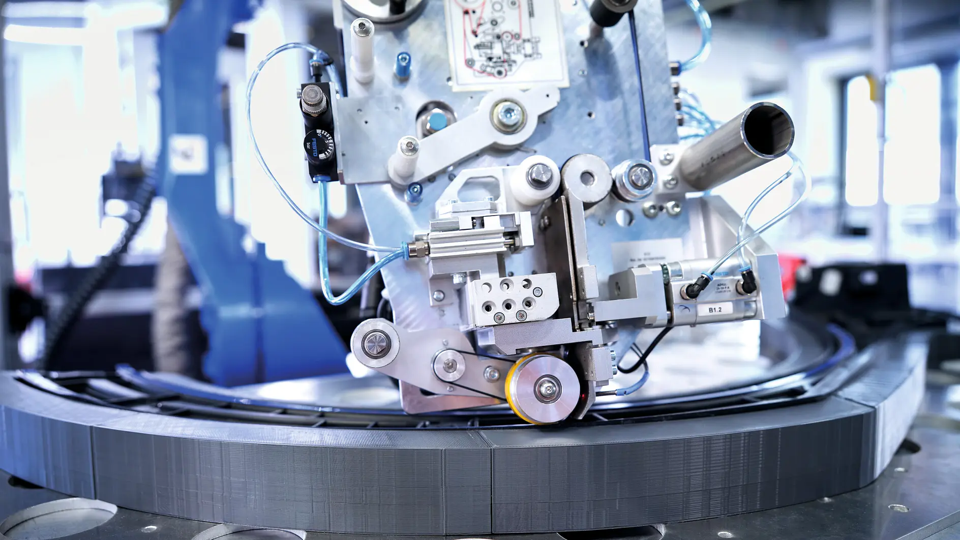 tesa industrielle Maschinenmontagekomponenten auf einer kreisförmigen Metallplattform in einer Fabrikumgebung