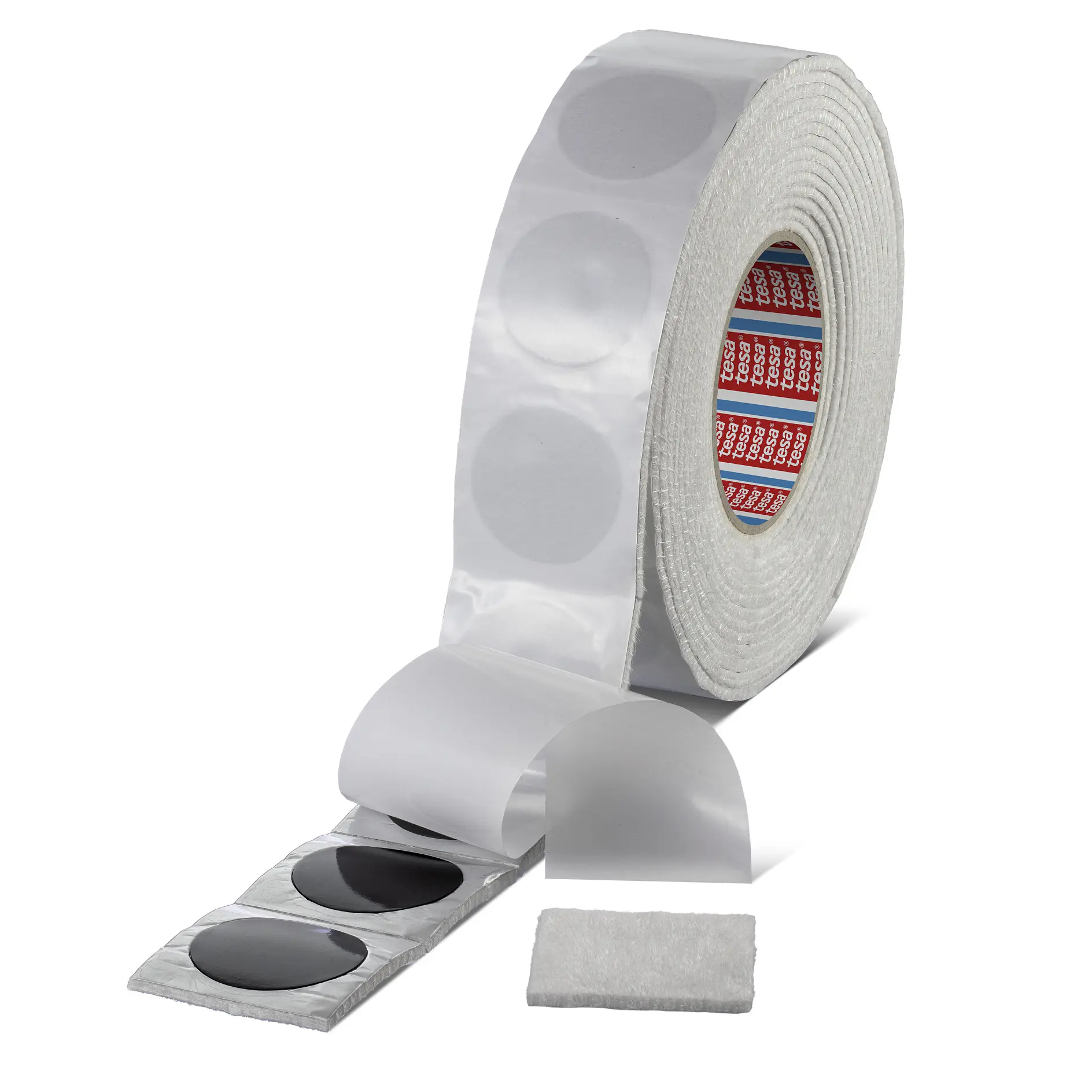 Roll of tesa clear adhesive dots with one dot peeled off and a small white fabric square on a white background (This text has been generated by AI)