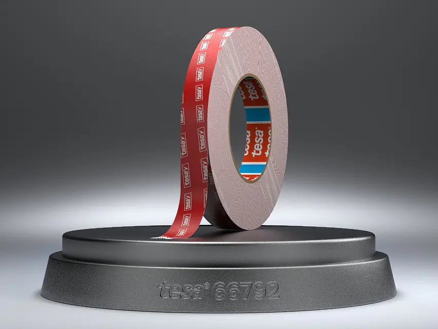 A roll of red adhesive tesa tape is displayed upright on a circular black stand against a gradient gray background. The tesa tape features white text on its surface.