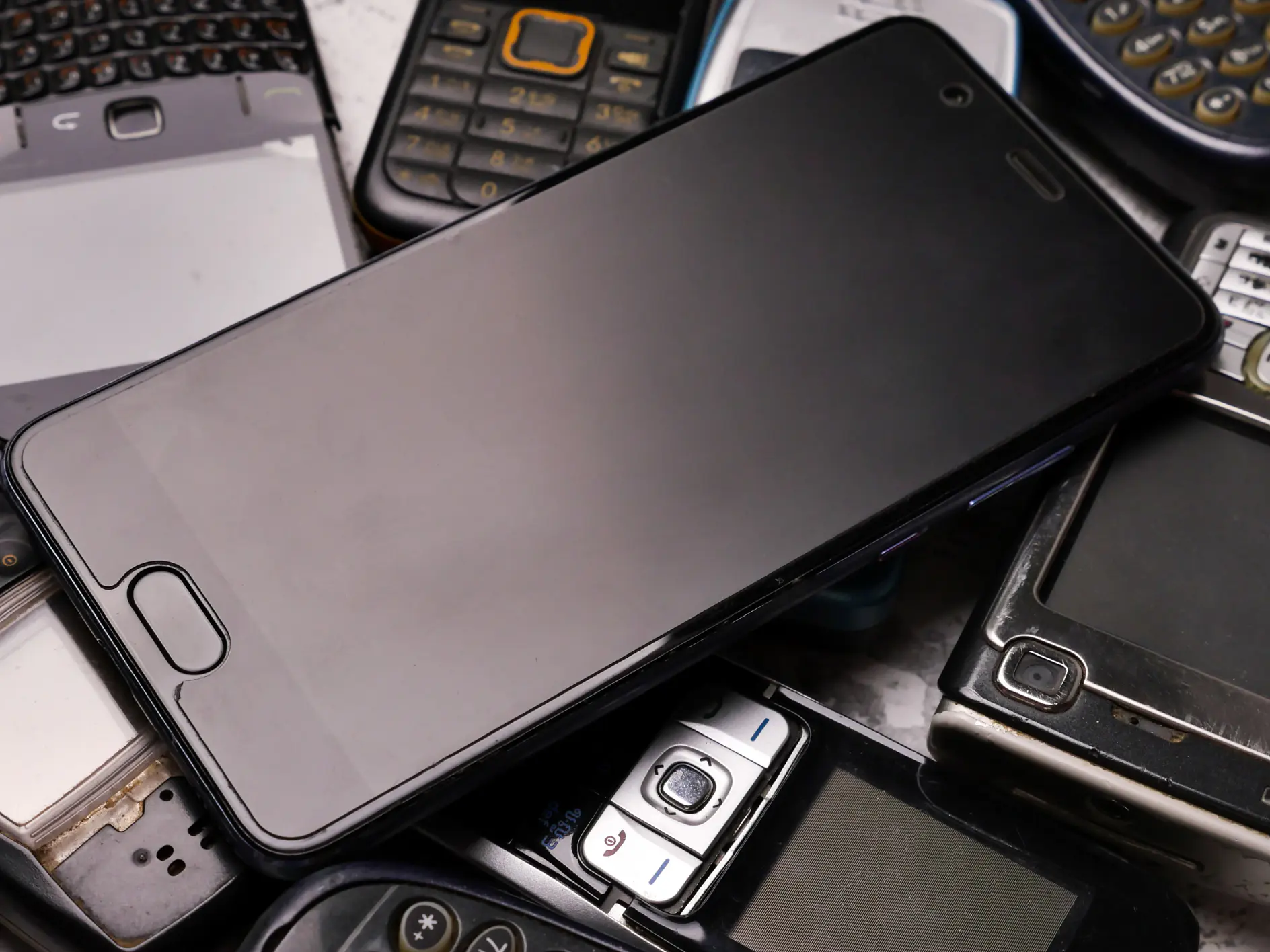A smartphone on pile of obsoleted cellphones.