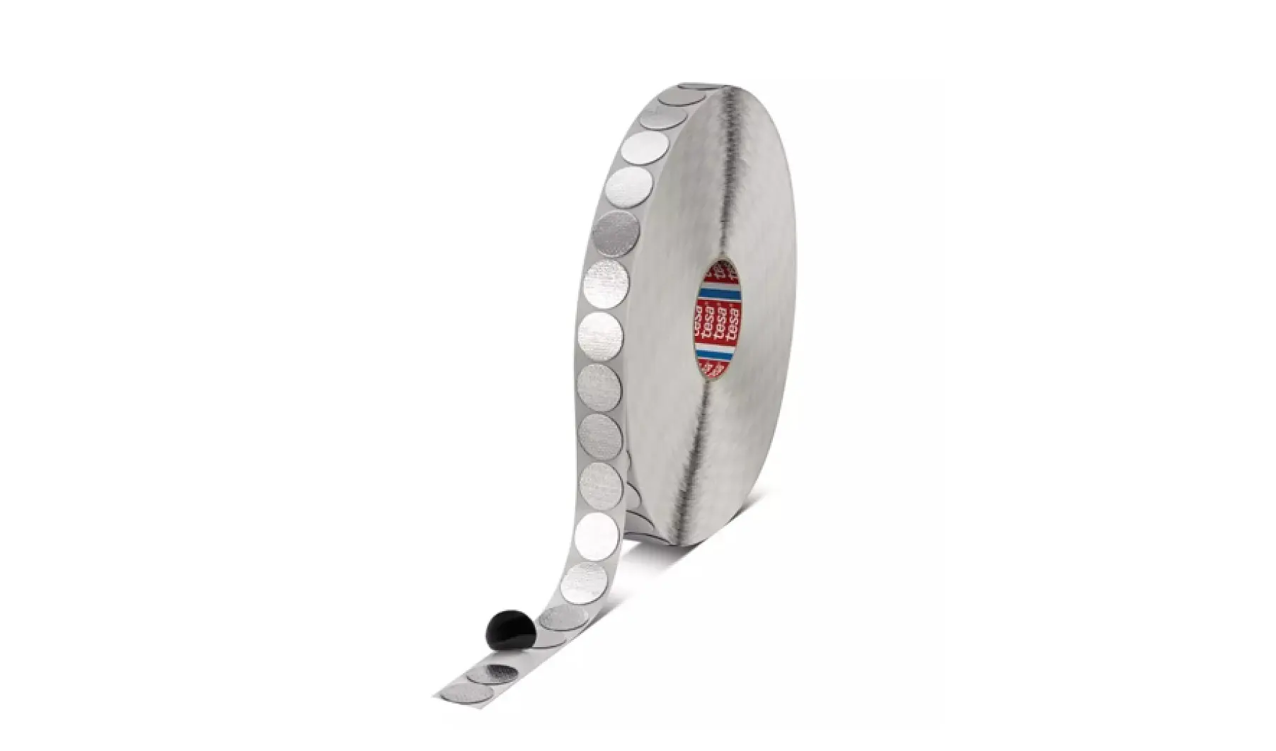 A large roll of self-adhesive Velcro dots is shown. The tesa tape features evenly spaced circular dots, with several dots visible on the unrolled portion. The roll has a grey appearance and is positioned against a white background. (This text has been generated by AI)