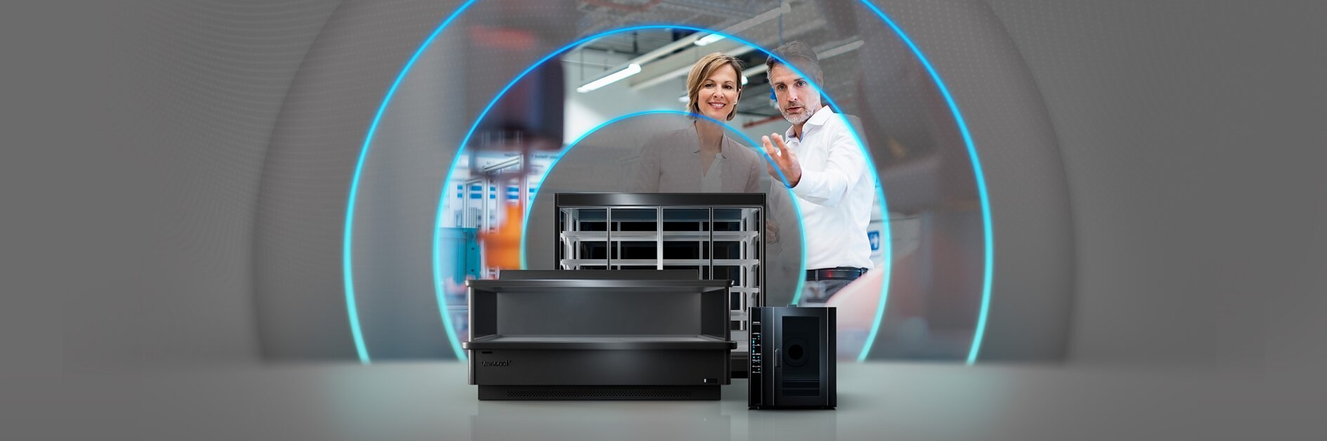 A man and woman are interacting in a high-tech setting with large electronic equipment in front of them. They appear focused on their surroundings, with a blue glowing arc in the background. There is tesa tape placed strategically around the equipment for securing cables and components neatly. The versatility of tesa tape makes it an ideal choice for managing intricate setups like this one.