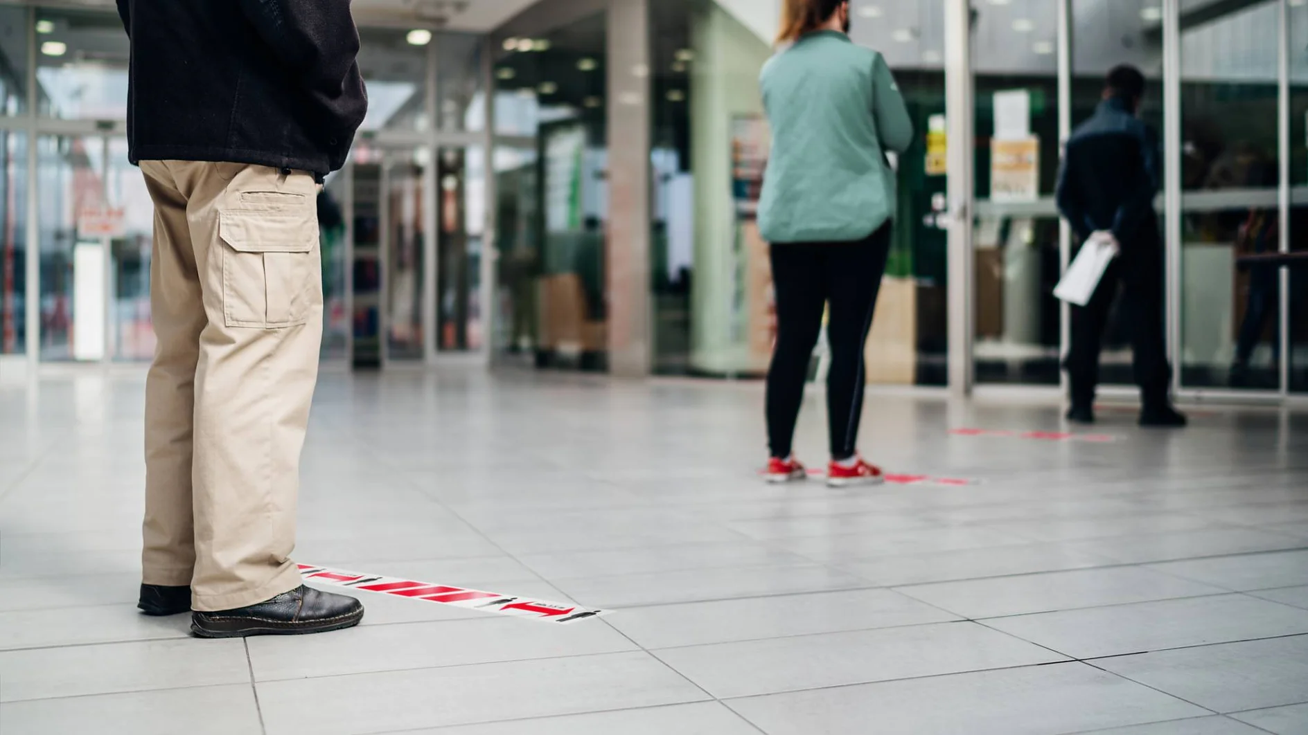 People standing in line front of bank/store due to coronavirus pandemic safety guideline.COVID-19 safe social distancing practice.Quarantine financial crisis,banking,loans.Spaced out queue.Crowd-limit