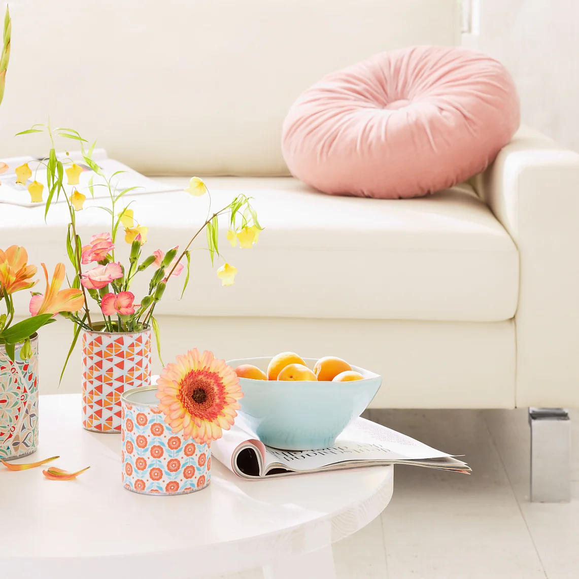 Simple white tin cans hide under the cheerful fabric patterns on the vases. They are quick and easy to make, so you might even make a few more for your friends ...