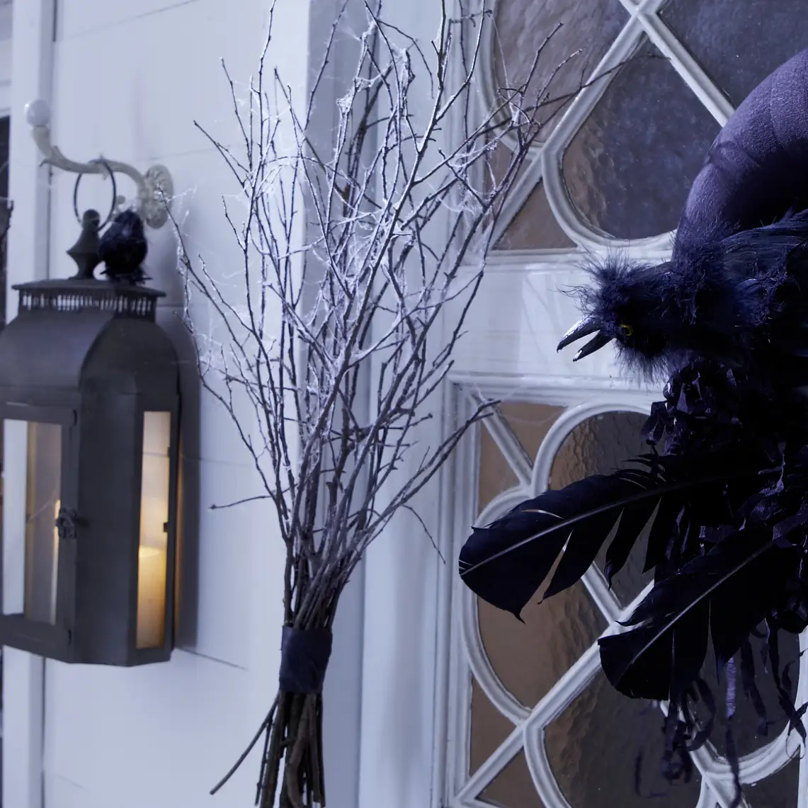 A black raven in its nest is guarding the door on Halloween.