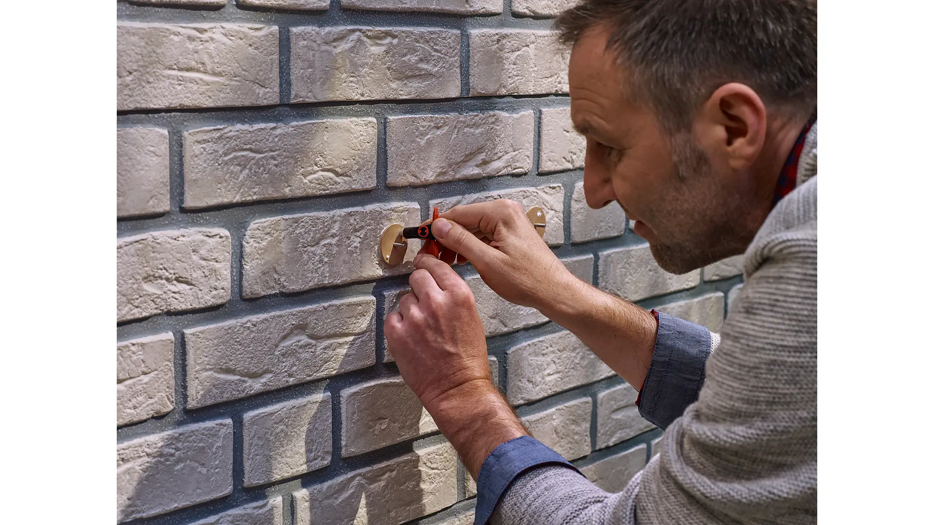 Applying the adhesive to a tesa® Adhesive Screw Round for Brick & Stone 10kg.
