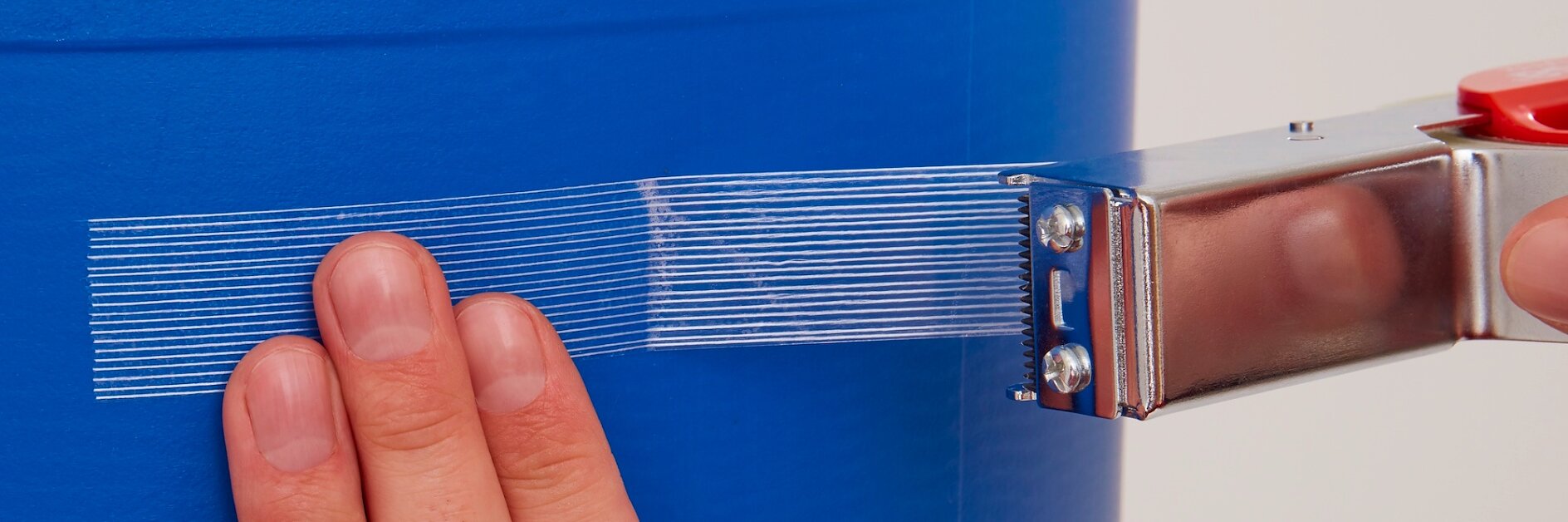 Hand applying reinforced tapes for strong adhesion and durable bonding in packaging and industrial applications.