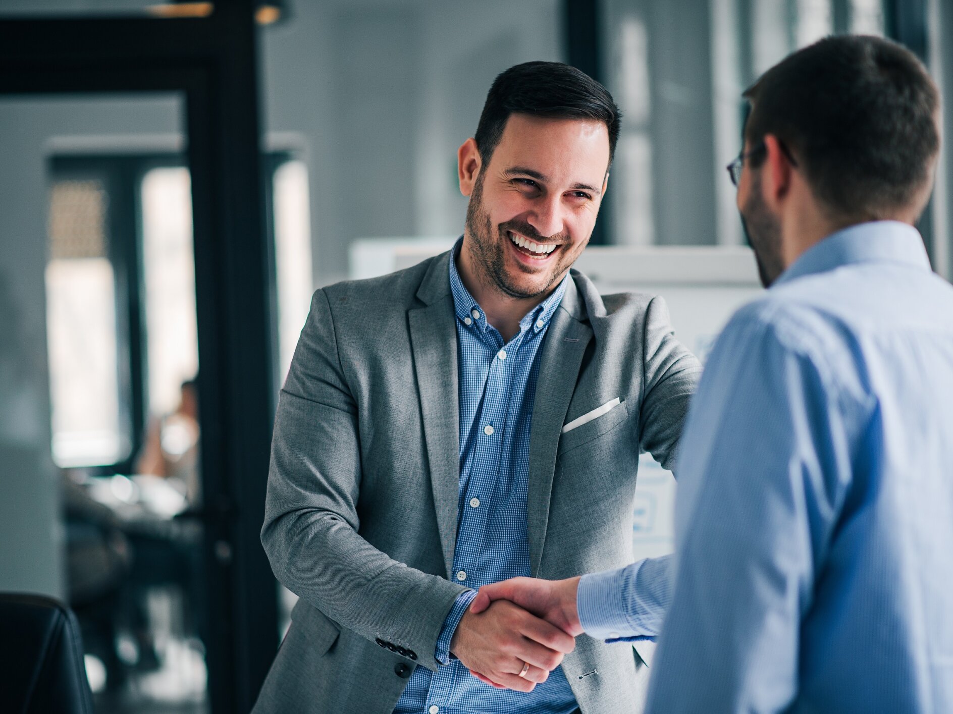 Portrait of cheerful young manager handshake with new employee.