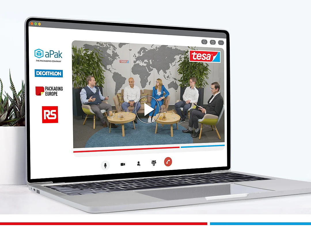 A laptop displays a virtual panel discussion with five people seated in a semi-circle. Logos of aPak, tesa tape, Decathlon, Packaging Europe, and RS appear on the screen. A large world map and plants are in the background. (This text has been generated by AI)