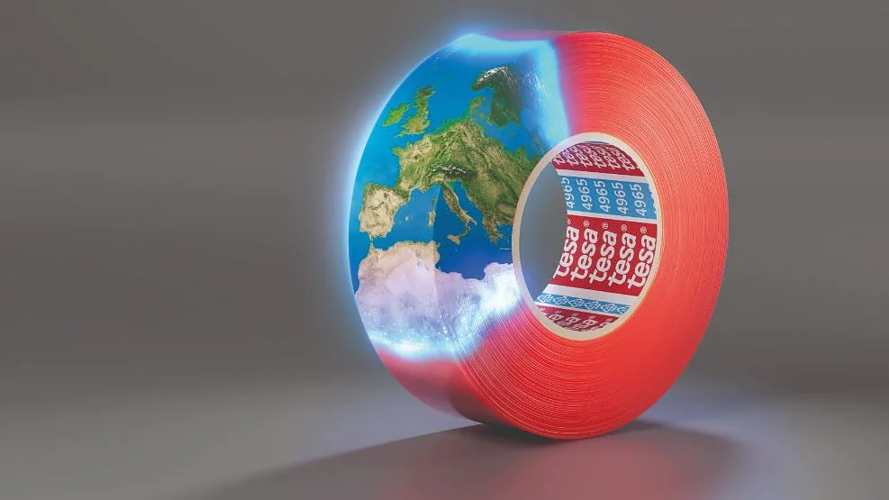 discover-4965-at-tff A roll of red tesa tape partially transformed into a semi-transparent globe, showing the continents of Europe and Africa. The globes section appears to be glowing, blending with the tesa tapes surface. (This text has been generated by AI)