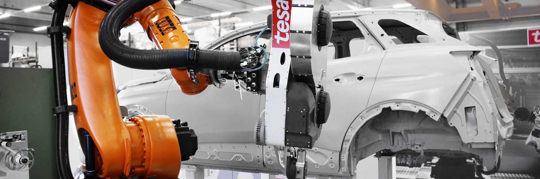 industrial robotic arm labeled tesa inspecting a white car body frame inside a modern automotive manufacturing facility (This text has been generated by AI)