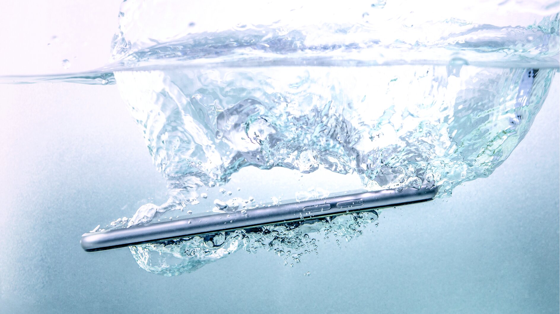 A smartphone submerged in water, creating bubbles and ripples in the surrounding liquid, is secured with tesa tape. (This text has been generated by AI)