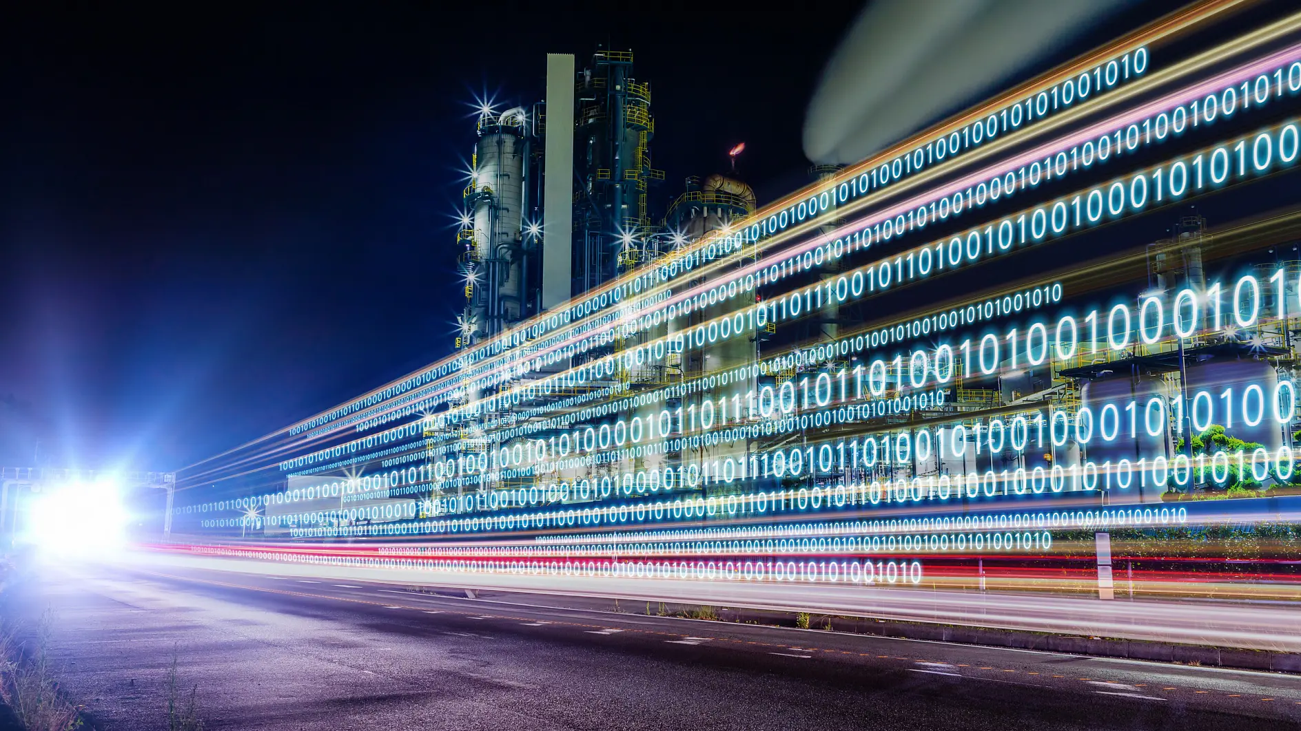 Night cityscape with light trails displaying binary code (0s and 1s) along a road, highlighting digital data flow in an urban setting.