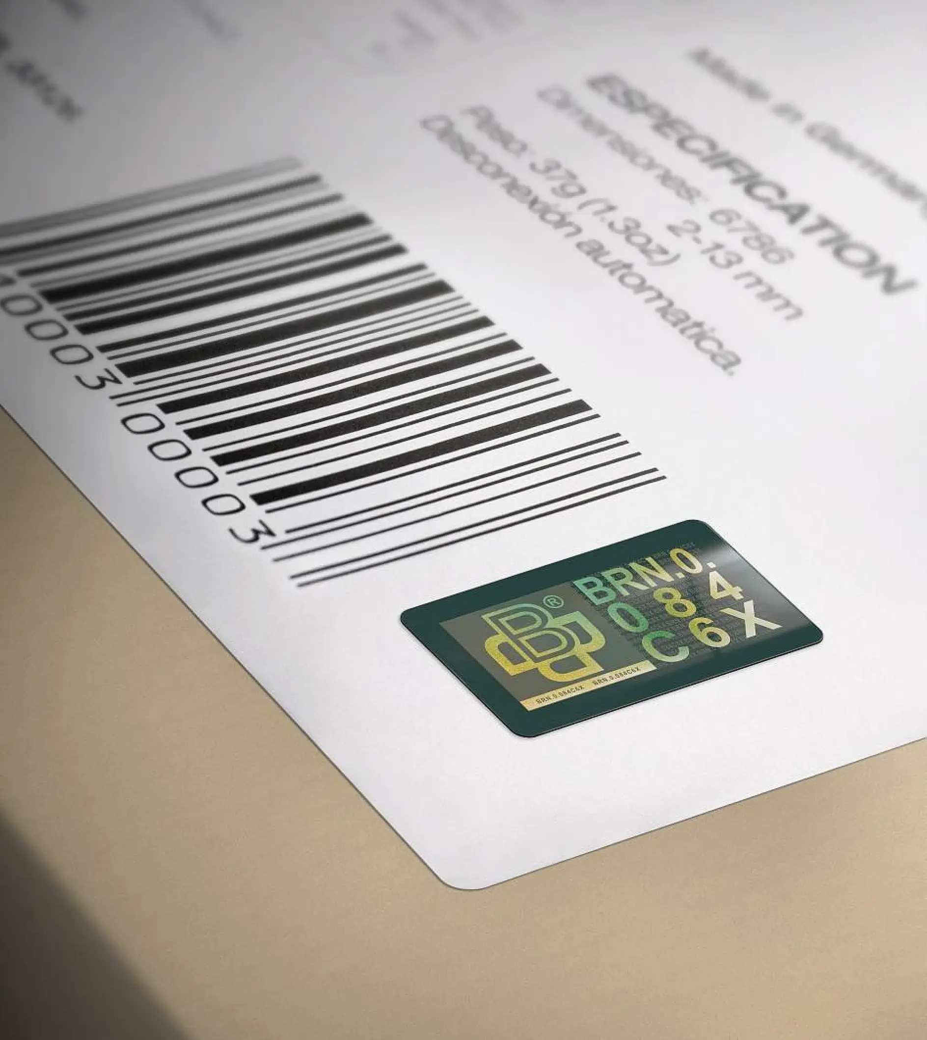 Close-up of a barcode label with a green and gold sticker adjacent to it. The sticker features stylized letters and numbers, including BRN 084 C6X. The label has partial text specifications and numeric codes.