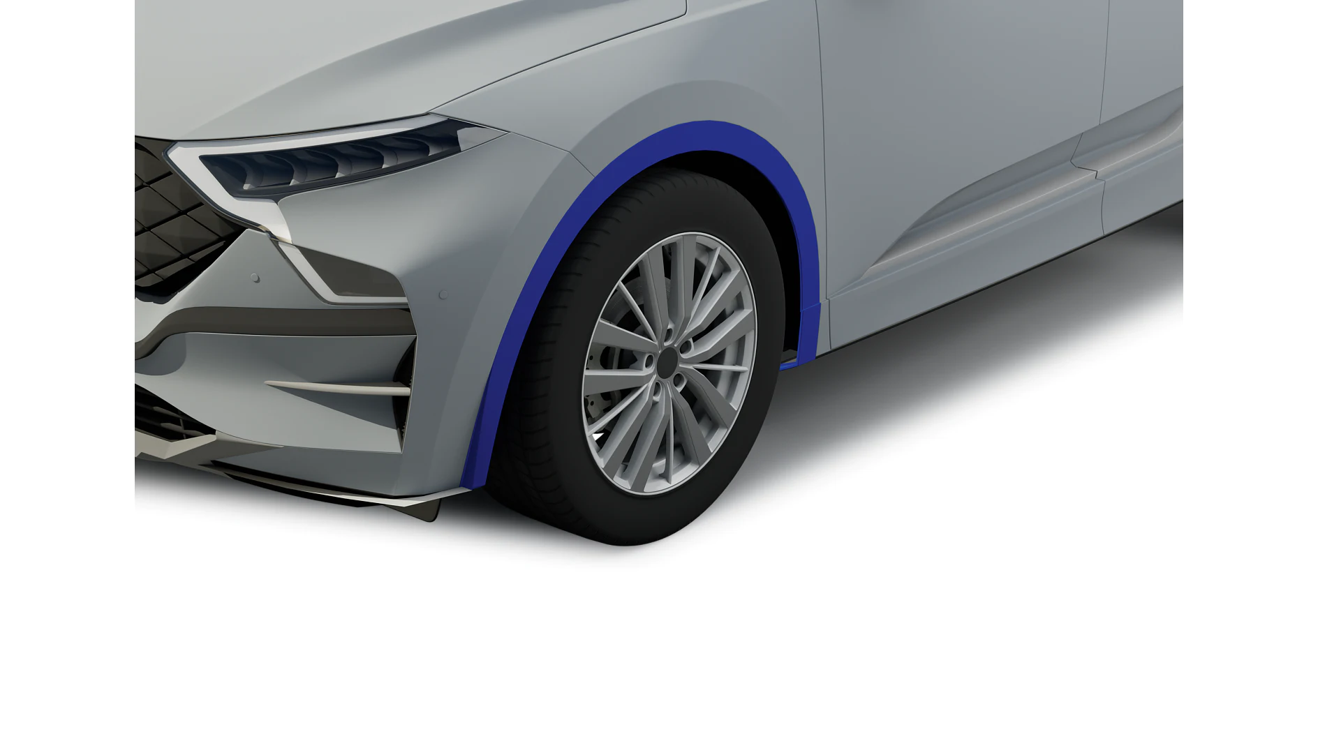 A close-up of the front left corner of a silver car, showing the wheel, tire, and part of the bumper. The car has a modern design with a blue accent around the wheel arch and sleek headlights. There are several pieces of *tesa tape* visible in this area. (This text has been generated by AI)