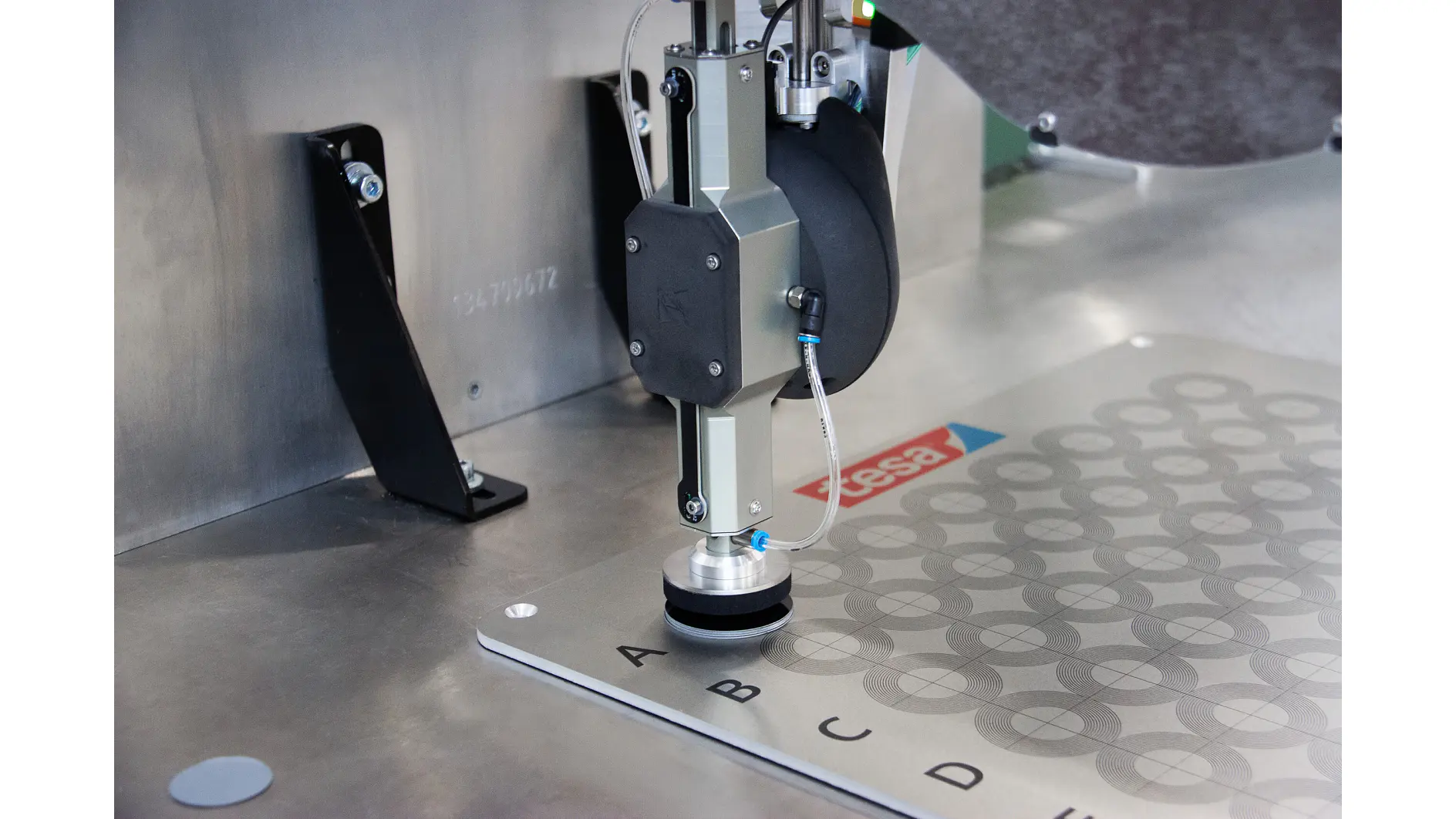 tesa industrial measuring device inspecting circular patterns on a metal surface in a laboratory setting (This text has been generated by AI)