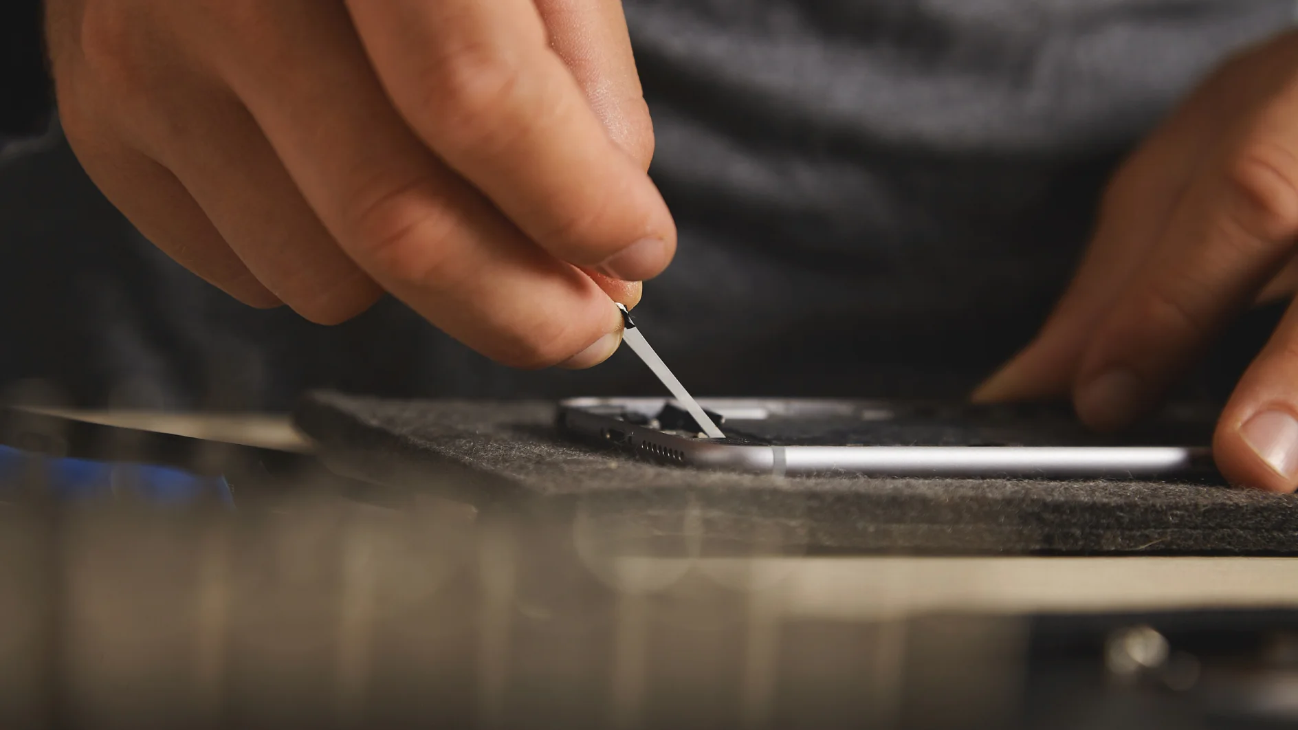 Using hands to remove battery glue from opened smartphone to replace and fix it with new one
