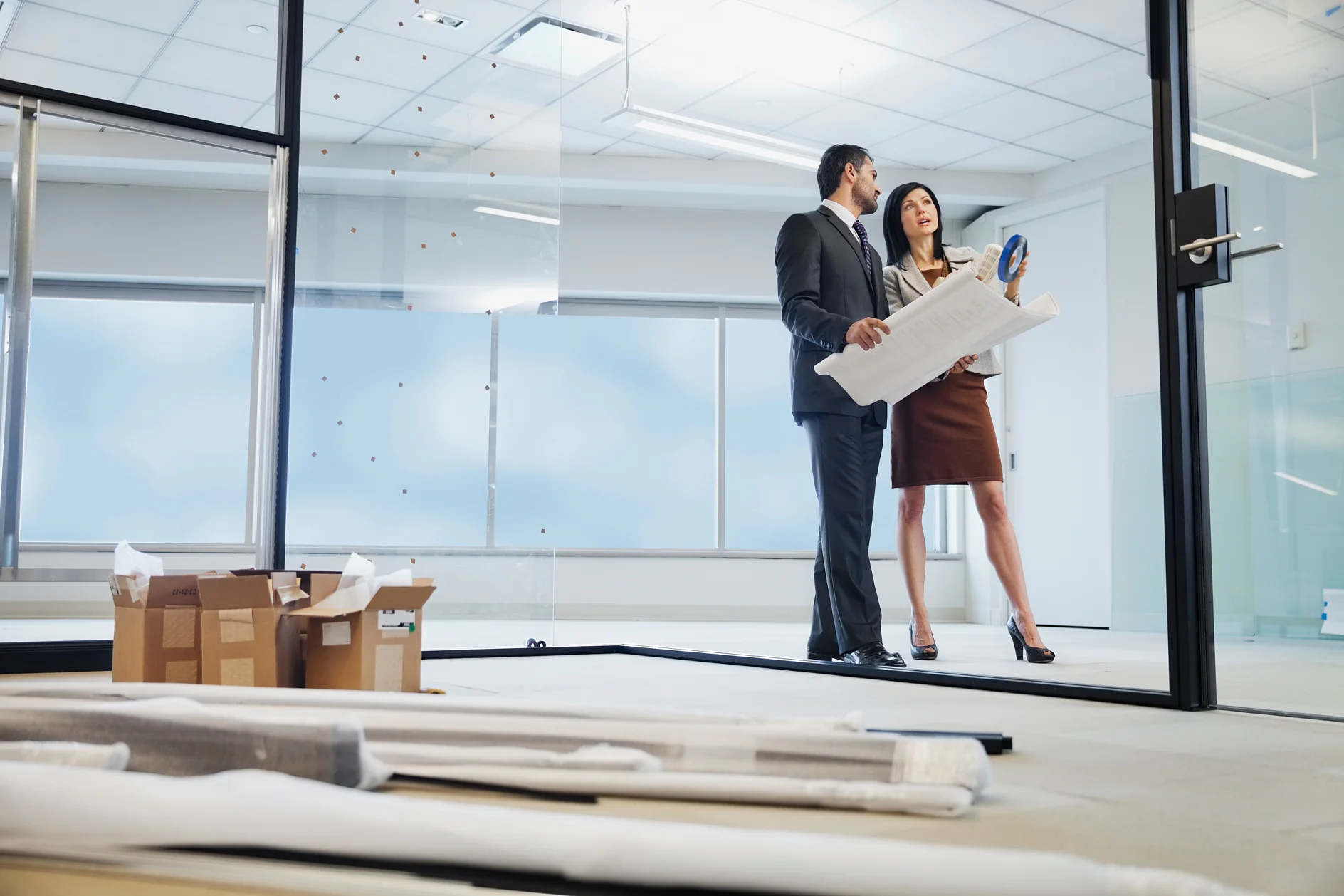 Removable tape used in building components. A man and a woman discussing plans for building components at a construction building site.