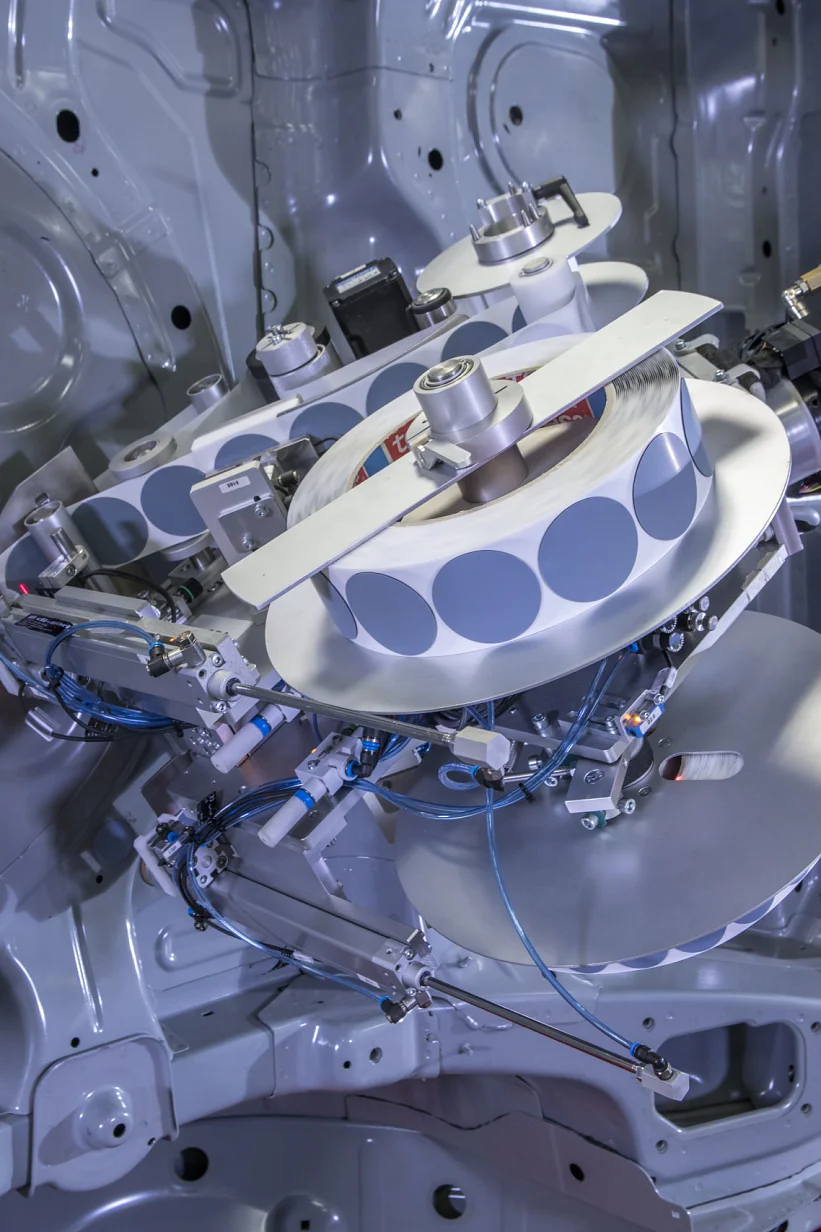 The adhesive pads from tesa are positioned quickly and reliably by a robot. Before this innovation, hole covering was an exhausting and time-consuming process, which had to be done by hand. (© tesa SE)