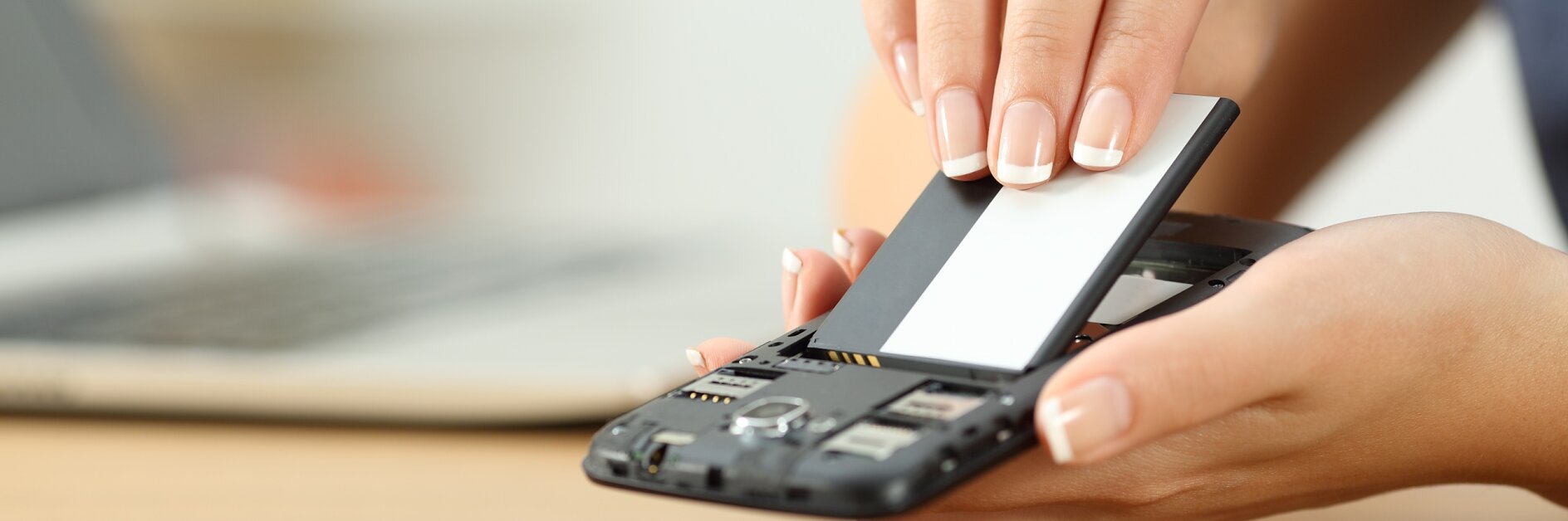 Close up of a woman hand putting a battery into a smart phone