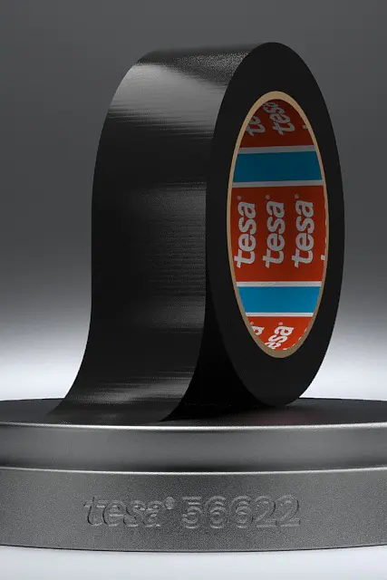 A roll of black adhesive tesa tape is partially unrolled on a round, gray pedestal. The tesa tape has a glossy finish, and the inner core is red with blue and white branding. The pedestal is inscribed with the text tesa® 56222. (This text has been generated by AI)