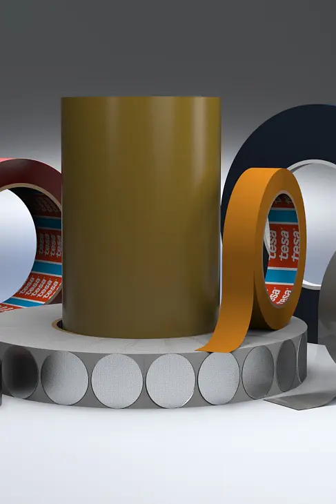 A variety of adhesive tesa tape rolls are displayed, including red, green, black, orange, blue, and white colored tesa tapes. Some rolls stand upright, while others lie flat. Circular, white stickers are also arranged among the tesa tapes. (This text has been generated by AI)