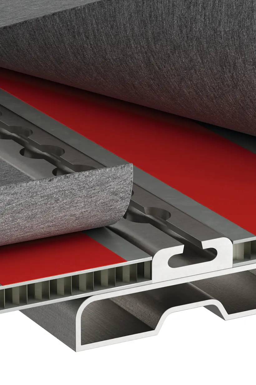 A cutaway illustration of a composite panel showing layers. The top layer is a grey sheet, partially peeled back to reveal a red layer underneath secured with tesa tape. The core appears to be a honeycomb structure, with a metallic framework at the bottom. (This text has been generated by AI)