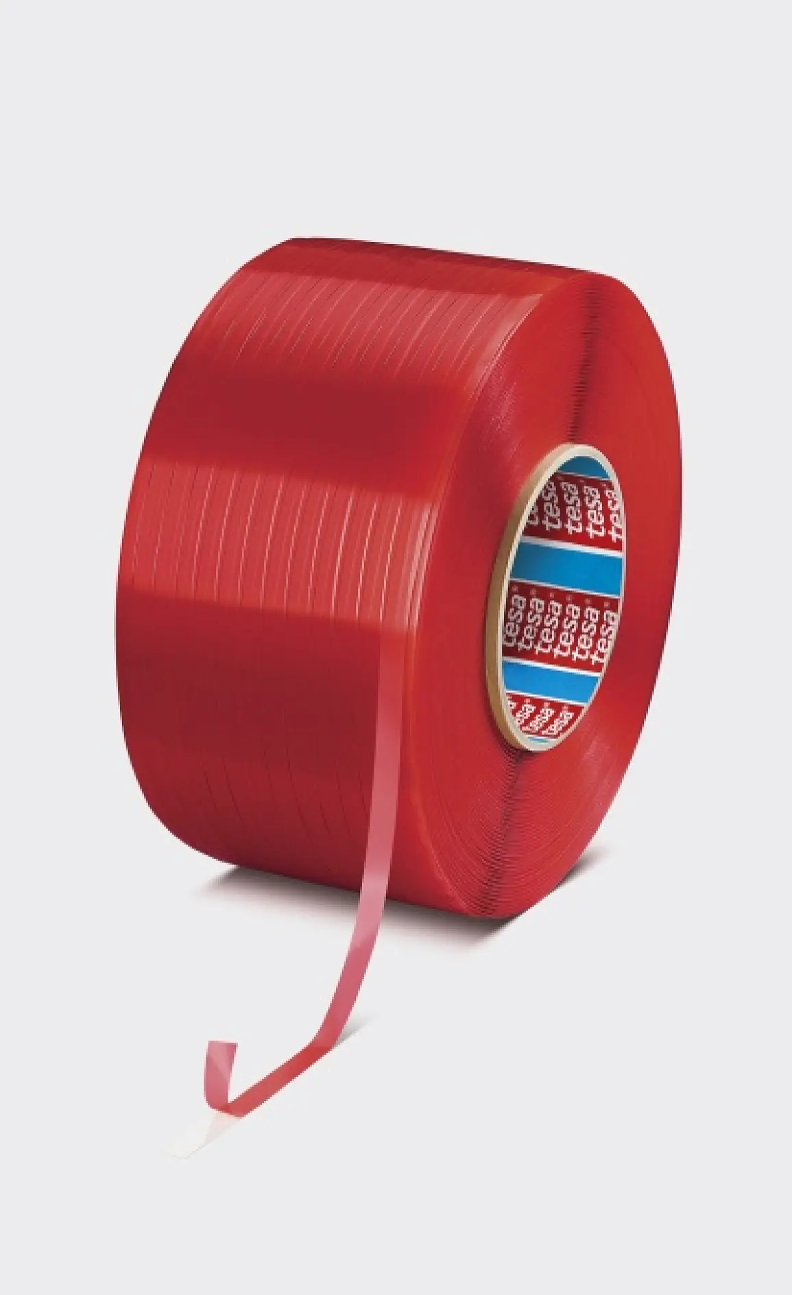 A large roll of red tesa tape stands upright on a light gray surface, with a short piece unwound and hanging loosely in front. (This text has been generated by AI)