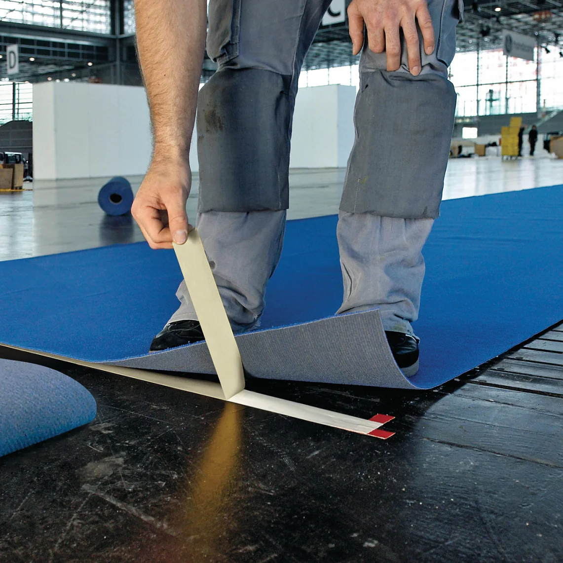 Professional Craftsmen Using Double Sided Floor Laying Tape To Fix Carpet