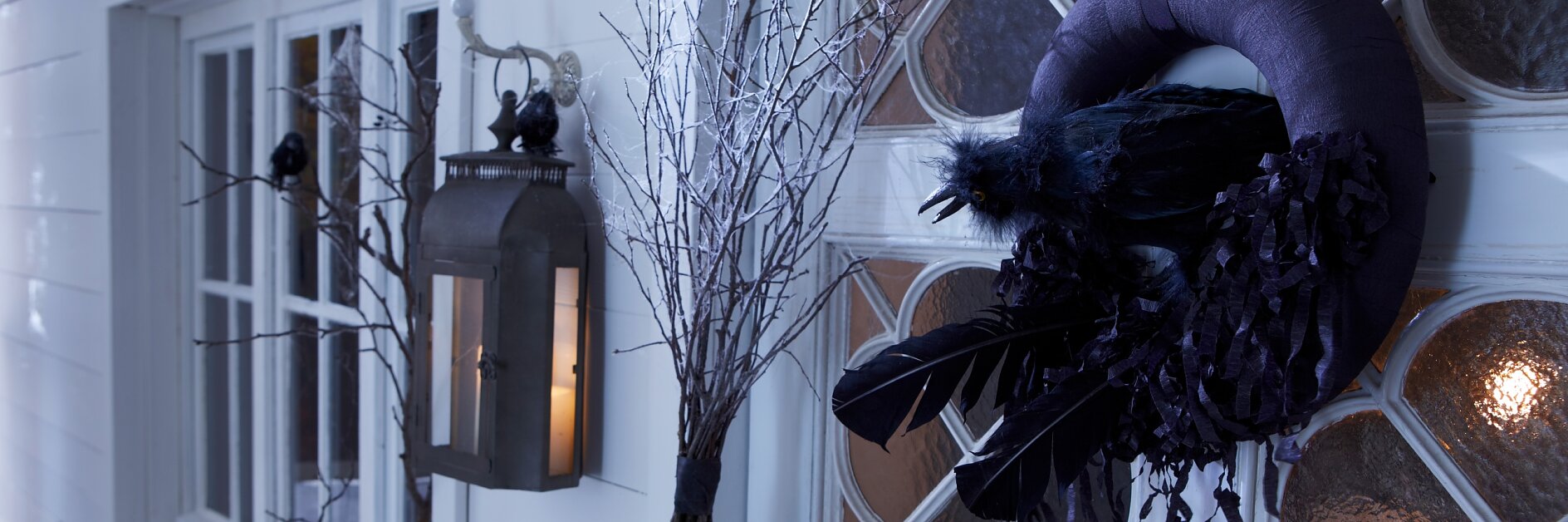 A black raven in its nest is guarding the door on Halloween.