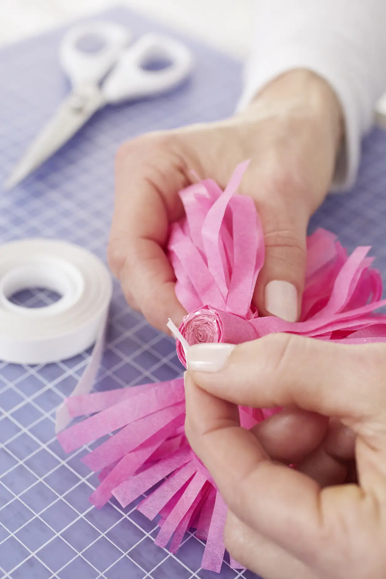 Apply a small piece of double-sided adhesive tape on the bottom of the pompom