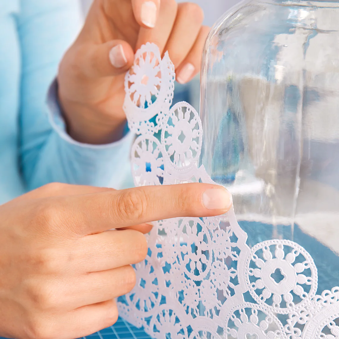 Position and stick the doily to the glass vase to create your own DIY vase